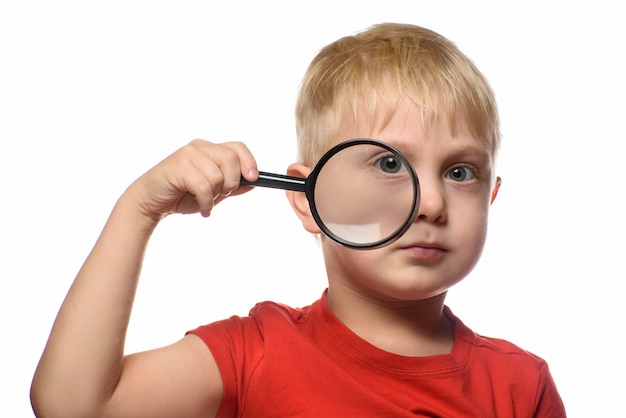 Blond boy with a magnifying glass in his hand