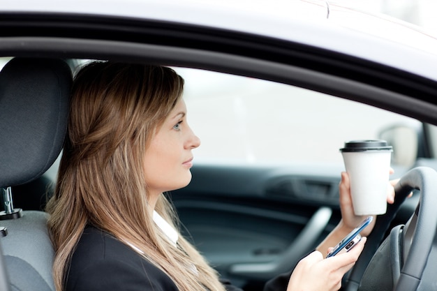 運転中のテキストを送る金髪の実業家