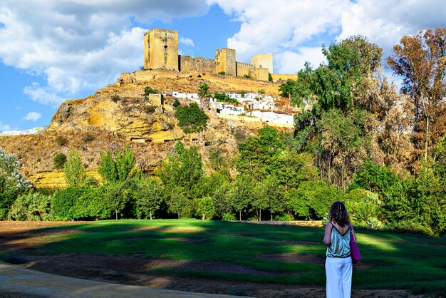 세비야의 Alcala de Guadaira 성을 바라보는 금발 곱슬머리 여성.