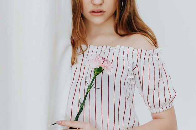 Blond girl holding a single carnation