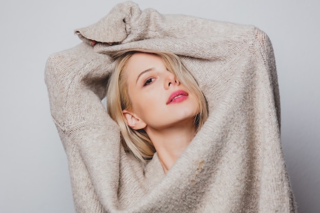 Blond hair girl in sweater on white background