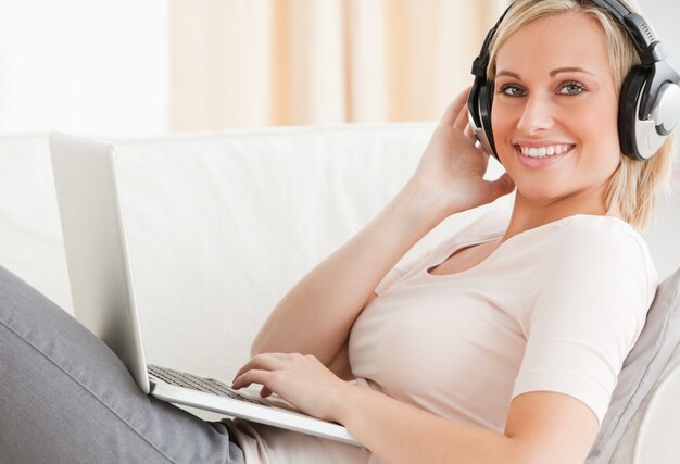 Blond-haired woman watching a movie on her laptop