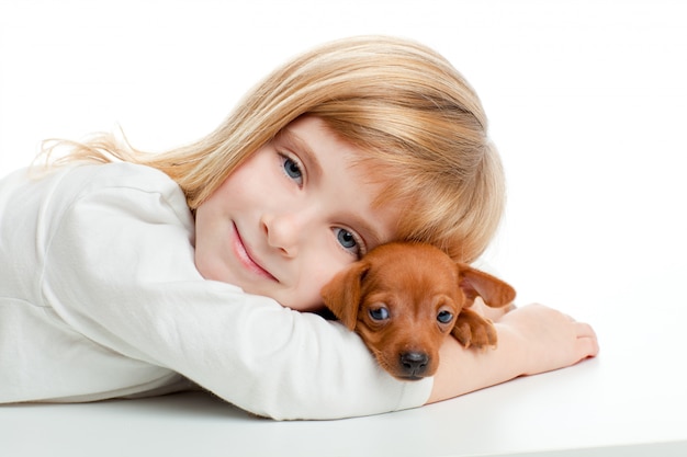 blond jong geitjemeisje met de minigiftende hond van de pinscherhuisdieren