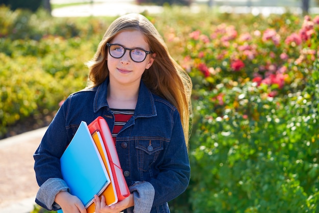 Ragazza bionda dello studente del bambino nel parco con i vetri