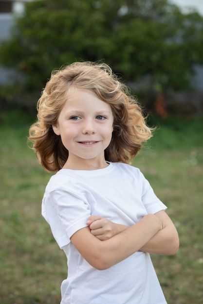 Blond kid with long hair outdoors
