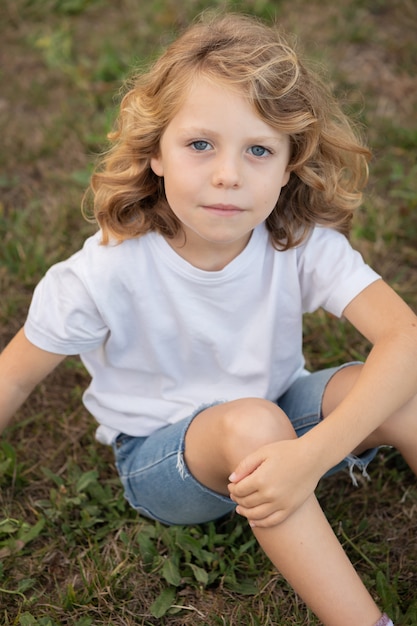 Blond kid with long hair outdoors