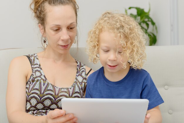 金髪の少年と彼の母親のデジタルタブレット