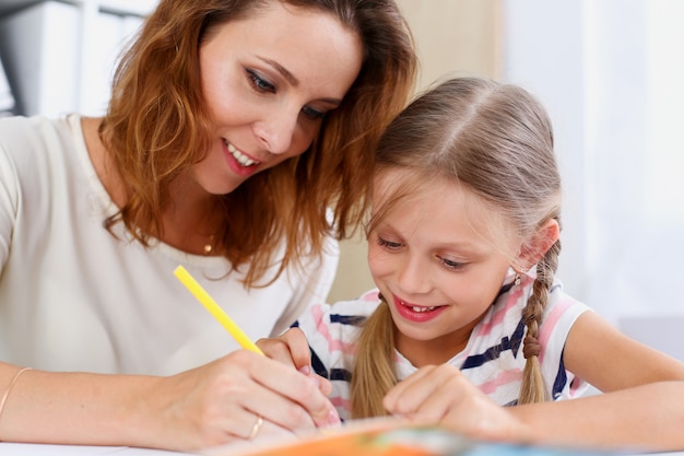 Blond little girl hold in arm pencil drawing something