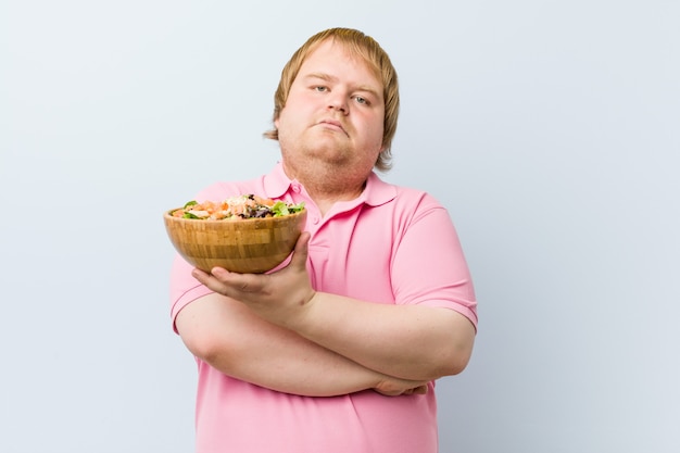 Blond man holding a salad bowl