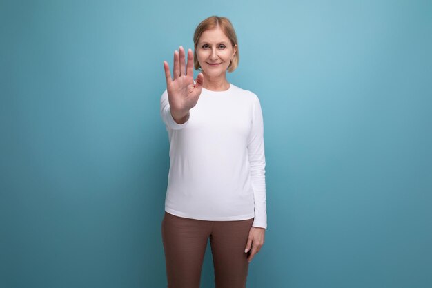 ブロンドの成熟した女性が手で意見の相違を示すジェスチャーをしている