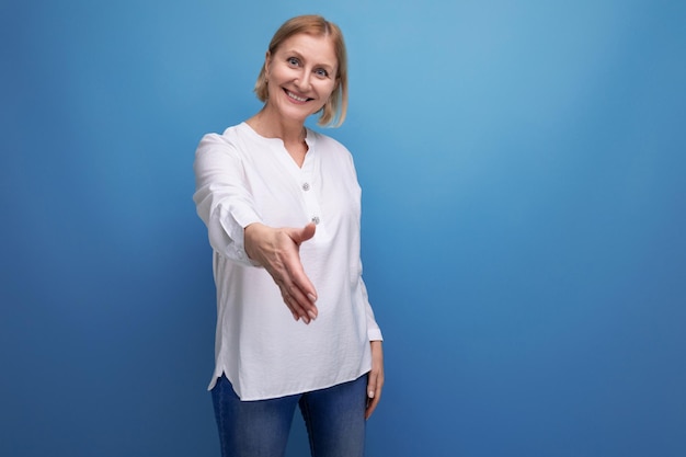 Blond mature woman in white blouse wants to shake hands