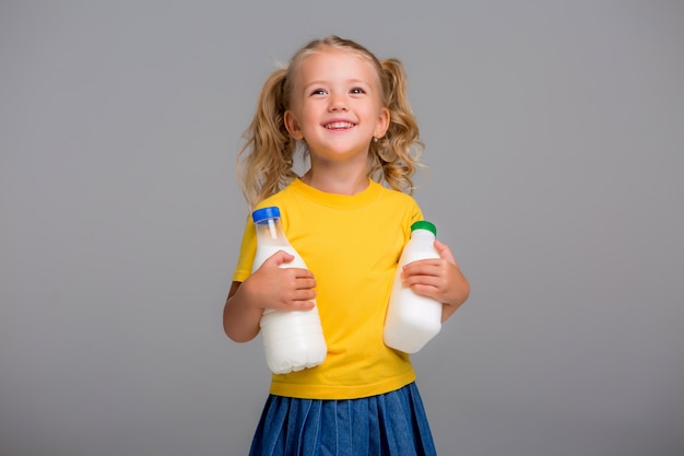 blond meisje houdt van plastic flessen melk