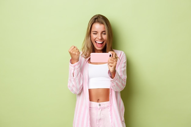 Blond meisje in een roze outfit poseren