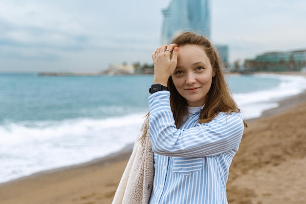 Blond meisje loopt langs de zee