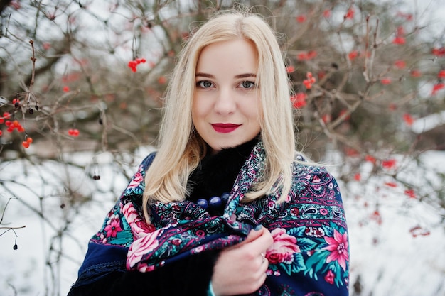 Blond meisje met hand geborduurde sjaal gesteld op winterdag. Dames zakdoek.