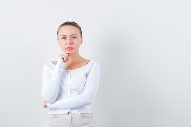 Blond meisje poseert voor de camera op een witte achtergrond