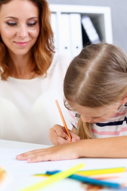 Blond meisje tekenen met haar moeder
