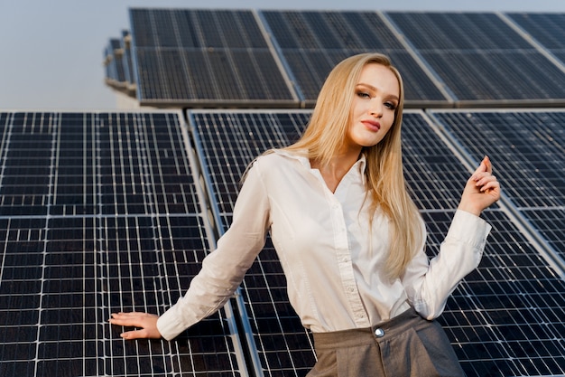 Blond model met zonnepanelen staat in rij op de grond