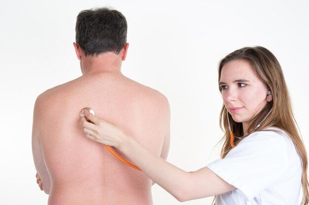 Blond pretty doctor Examine Patient&amp;#39;s Back With Stethoscope