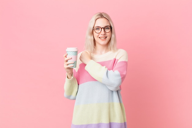 Bella donna bionda che si sente felice e affronta una sfida o festeggia. concetto di caffè