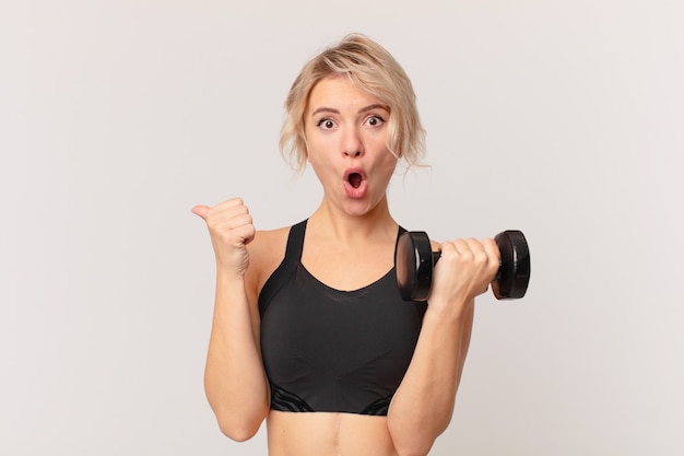 Blond pretty woman lifting a dumbbell