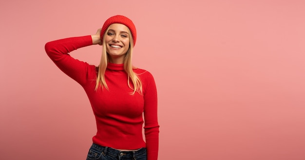 Foto blond schattig meisje glimlacht met rode hoed en vest