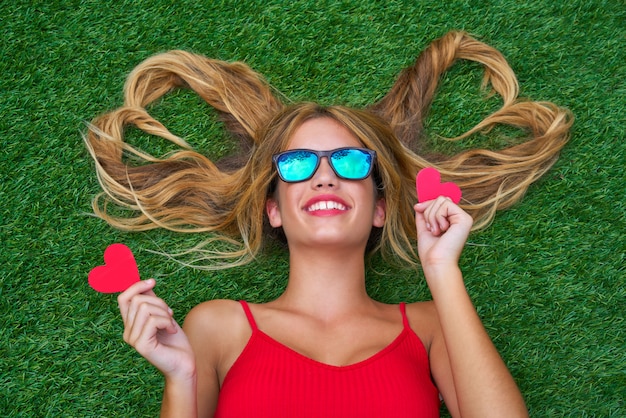 Blond teen girl with hair heart shapes lying