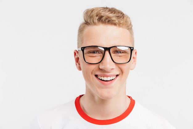 blond teenage guy having clean healthy skin wearing eyeglasses smiling with white teeth isolated on white