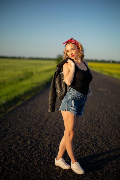 Blond tienermodel in rode bandana op de weg