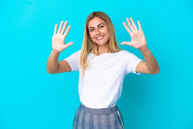 Blond uruguayaans meisje geïsoleerd op blauwe achtergrond die tien telt met vingers