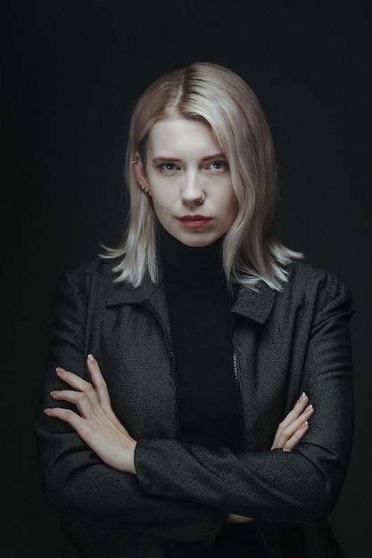 Blond woman in grey jacket, business style. Serious female worker. Self Confident girl.