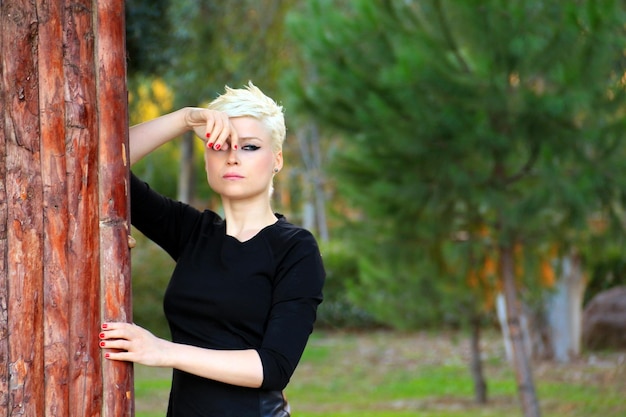 Blond Woman near the Wood Wall in Park