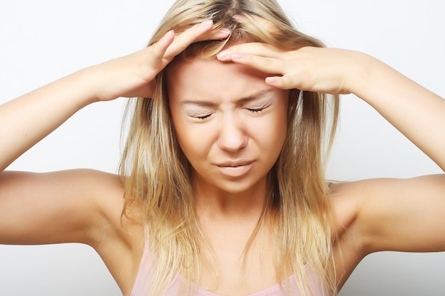 Blond woman with a headache holding head