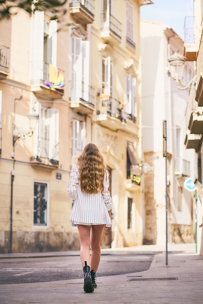 Blond young woman walking away from camera attractive and stylish woman