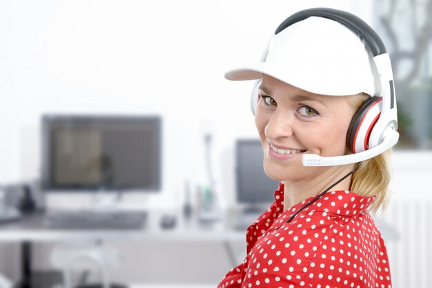 Blond young woman with headset and white cap