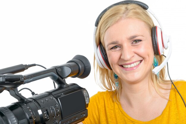 Blond young woman with professional video camera, on white