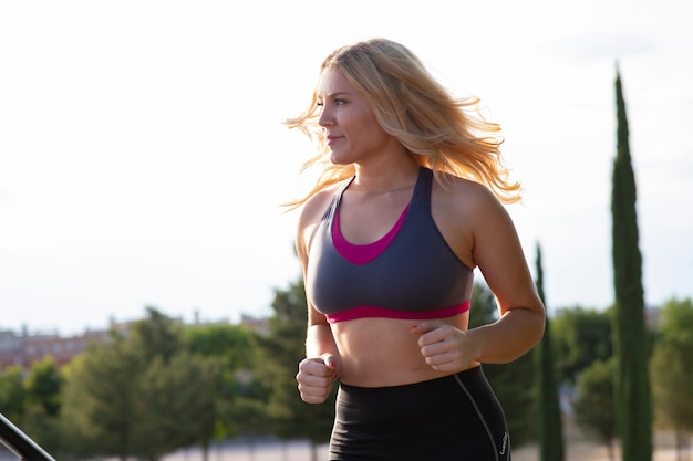 Blonde athlete woman in a top, running