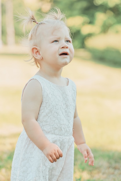 Blonde babymeisje in het park in de zomer. Hoge kwaliteit foto