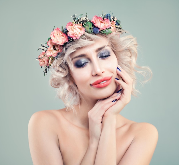 Modello di moda donna perfetta bellezza bionda con trucco luminoso fiori primaverili e taglio di capelli biondo bob