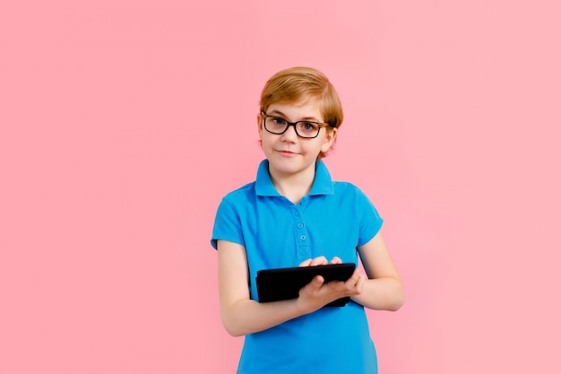 Blonde boy in t-shirt holding a tablet