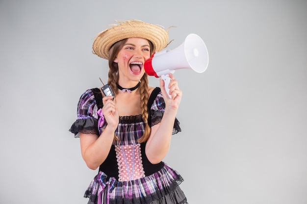 Blonde Braziliaanse vrouw juni feestkleding arraial megafoon muntsleutel