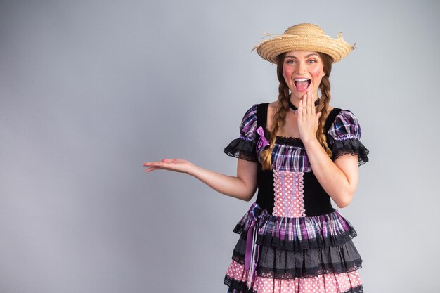 Blonde Brazilian woman June party clothes arraial showing an ad on the side advertising space