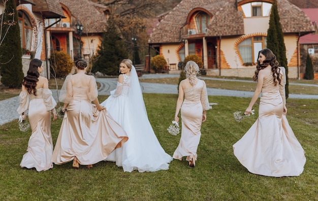 a blonde bride in a long wedding dress and her friends in beige dresses