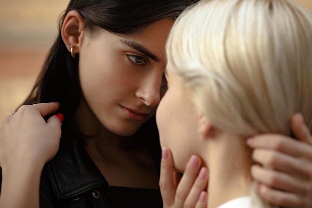 Blonde and brunette young lesbians looking at each other