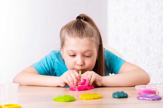 A blonde child blows a slime bubble