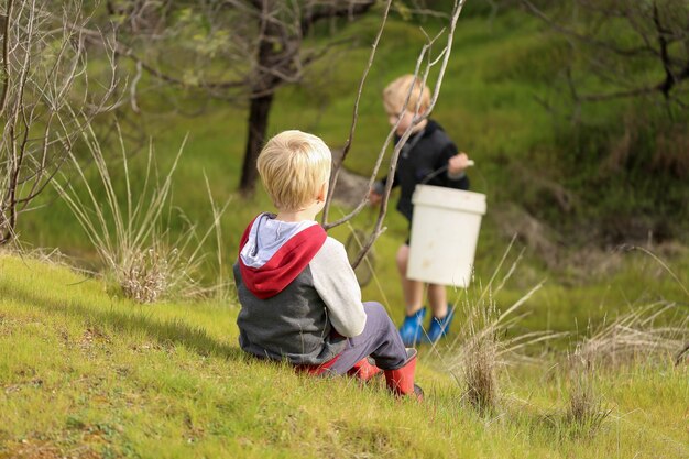 Blonde children preparing to catch some fish with a hand net in nature