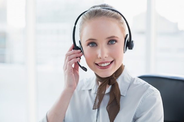 Blonde content businesswoman wearing a headset