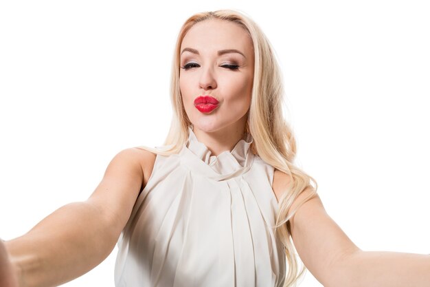 Blonde doing selfie on isolated white background taking picture