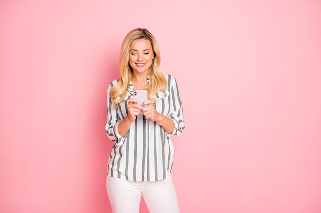 Blonde fashionable lady posing against the pink wall