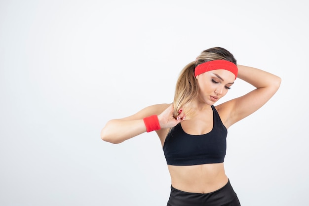 Blonde fit vrouw in zwarte sportkleding poseren.